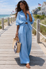 Woman in a blue outfit walking on a wooden boardwalk by the beach.