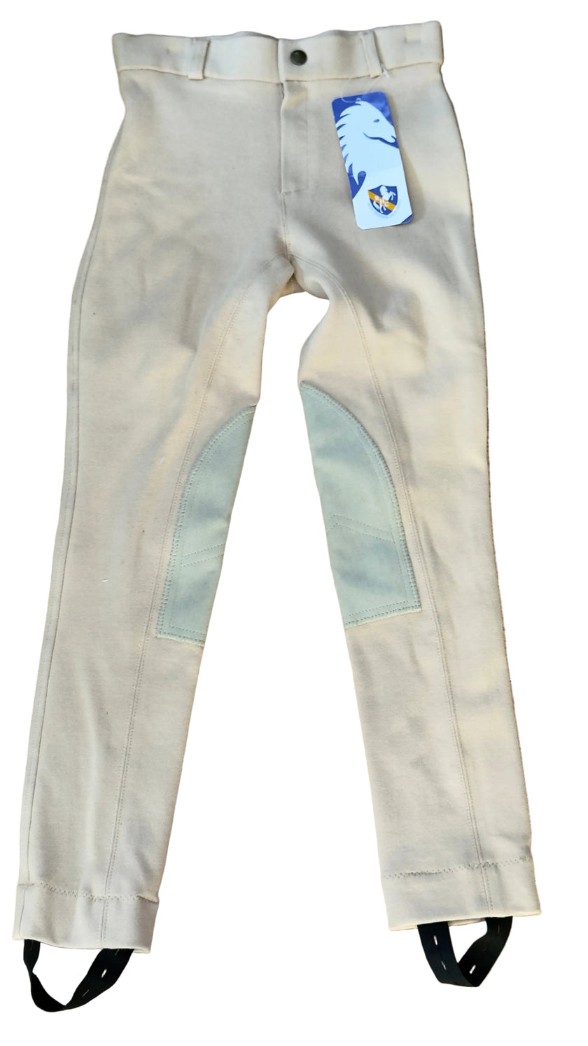 Beige riding pants with gray patches on a wooden floor, featuring a brand tag.