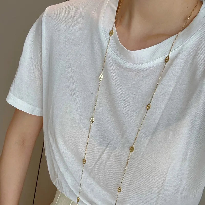 Long gold-tone oval station necklace displayed doubled