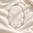 Open Clover Silver: Silver-tone stainless steel necklace with open quatrefoil stations and a 5 cm extender.