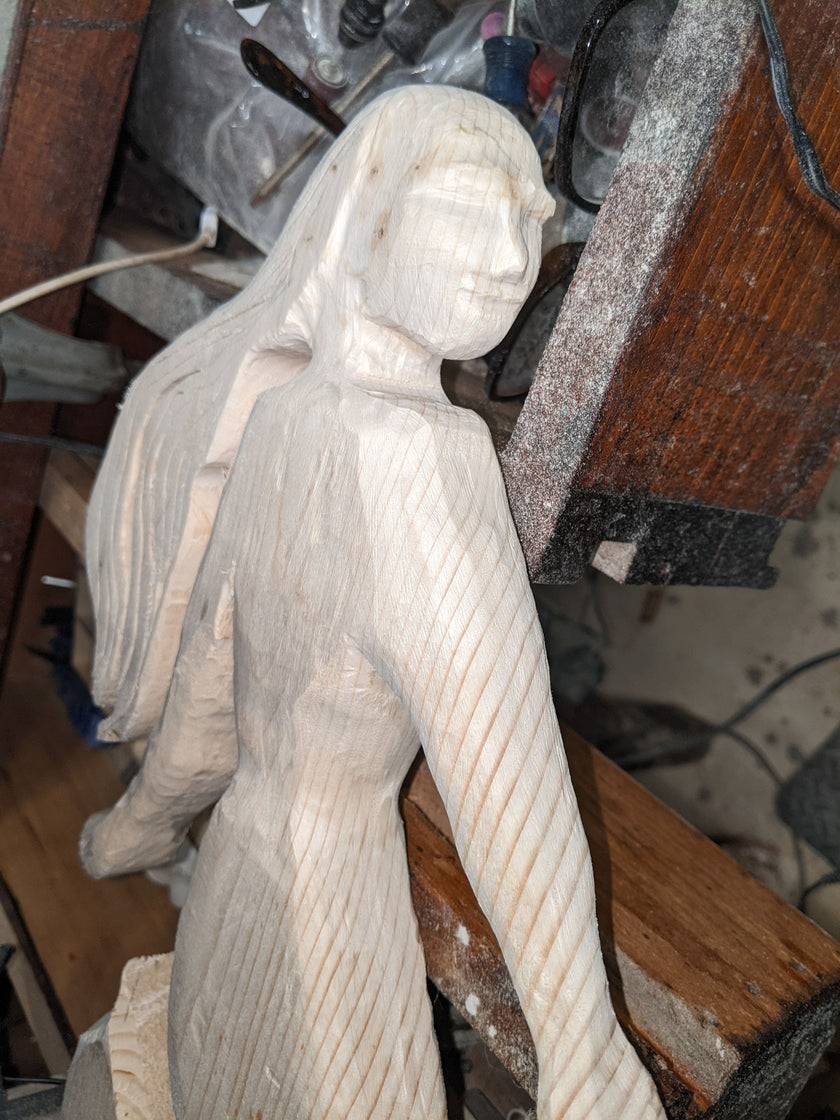 Carved wooden figure in a workshop setting