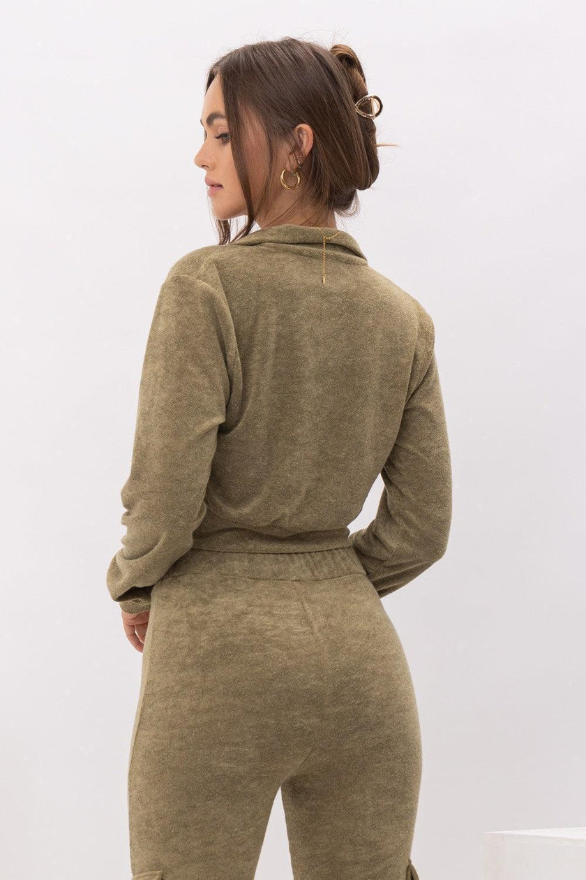 Woman wearing a green tracksuit against a white background