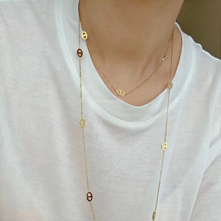Long Oval Gold: Long gold-plated stainless steel station necklace with open oval details, measuring 120 cm.