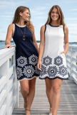women wearing Navy blue white sleeveless embroidered mini dress with navy trim front view