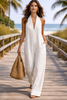 women blue wide leg jumpsuit summer travel outfit ocean background