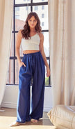 woman wearing a navy blue linen pants and white top